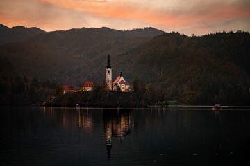 Picturesque sunset with the Bled castle with a tranquil lake in the foreground in Slovenia