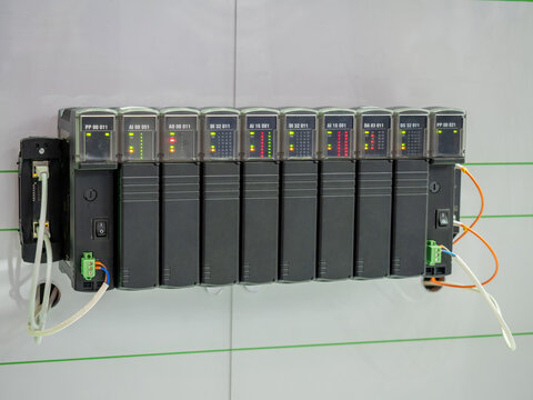 Programmable logic controller. Industrial electrical equipment. Logic controller with leds. Electrical appliance hangs on wall. Programmable controller for production automation. Power tech