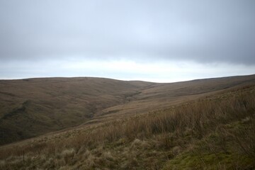 Scenic view of a valley with green hills on a cloudy day in Wales, UK