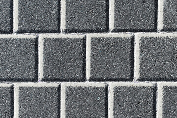Cobblestone pavement. Square shape bricks. Gray walking path. Paved texture. Street tile background. White fugue gray bricks backdrop.