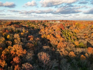 View of a farm surrounded by bright and vibrant autumn foliage, with stunning autumnal colors