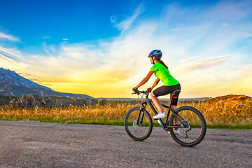 Beautiful woman cyclist rides a bicycle on a road. Healthy lifestyle and sports. Leisure and hobbies