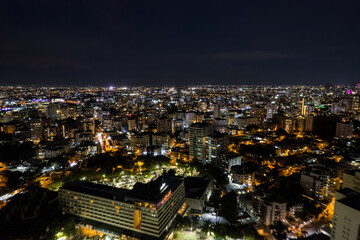 Fototapeta na wymiar Beautiful aerial Night view of the illuminated city of Santo Domingo - Dominican Republic with is Parks, buildings, suburbs ,turquoise Caribbean ocean, parks and malecon