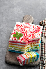 Multicolored rainbow cake on gray background