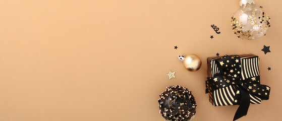 Stunning Xmas banner: Luxury gift boxes and black and gold Christmas decorations on elegant beige backdrop