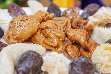 Assortment of chebakias, Moorish pasta and dates, on a white plate