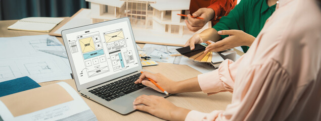 Cropped image of interior designer team discuss the material color while laptop displayed website wireframe designs for mobiles app and website. Creative design and business concept. Variegated. - obrazy, fototapety, plakaty