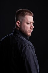 Strict and stylish Man in black shirt on dark background.
