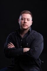 Obraz premium Strict and stylish Man in black shirt on dark background.