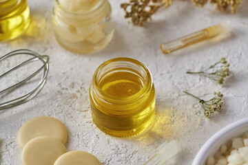 Essential oil in a glass jar with other ingredients for natural cosmetics