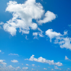 White fluffy clouds and bright sun on blue sky.