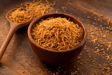 Grated coconut on wooden background.