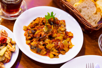 Saksuka, grilled turkish eggplants with tomato sauce in a white ceramic plate