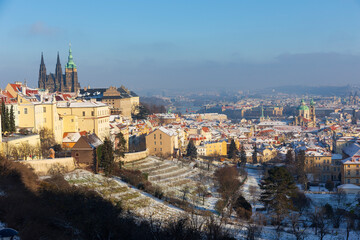 Snowy Prague City with gothic Castle in the sunny Day from the Hill Petrin, Czech republic