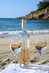 Summer time in Provence, two glasses of cold rose wine on sandy beach near Saint-Tropez in sunny day, Var department, France