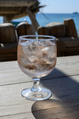 Summer time in Provence, glass of rose wine with ice cubes on bar terrace Pampelonne sandy beach near Saint-Tropez in sunny day, Var department, France