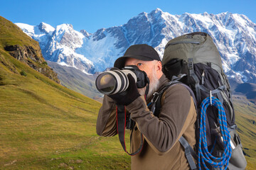 bearded man tourist photographer with a backpack photographs the beauty of nature in the mountains. nature hikes in the mountains