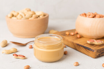 Fototapeta na wymiar Jar of peanut butter on concrete background, top view