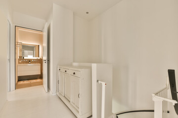 a room with white walls and flooring, including an open door that leads to a bathroom in the corner