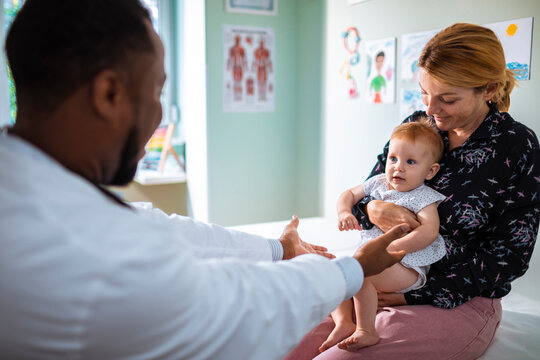 Mother with her cute baby visiting pediatrician in clinic