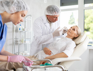 Woman getting procedure of injection contouring and for facial correction in cosmetology clinic