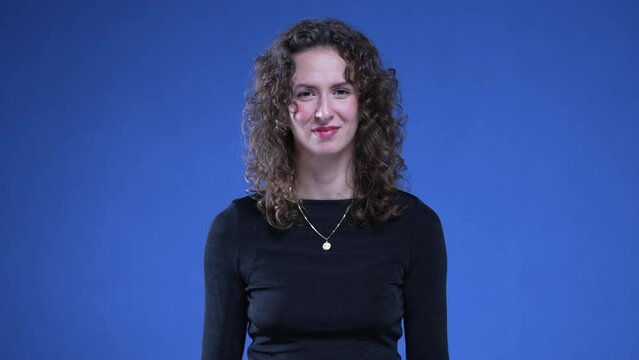 Young Woman in Shock Pointing to Herself Over Accusation signalling that accuser is crazy or wacky standing on blue background, pointing finger at herself in disbelief
