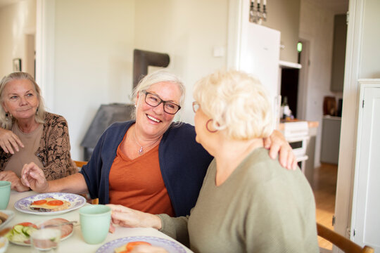 Female senior friends having breakfast together at home - Powered by Adobe