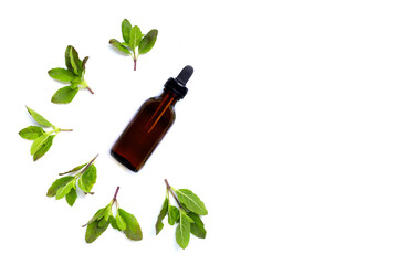 Holy basil essential oil with leaves on white