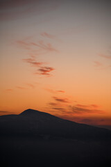 Scenery view of silhouettes of mountains and low clouds at colorful sunrise