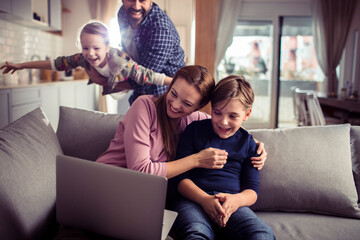 Young family having fun with laptop at home