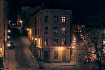 View of illuminated street amidst buildings at night - obrazy, fototapety, plakaty