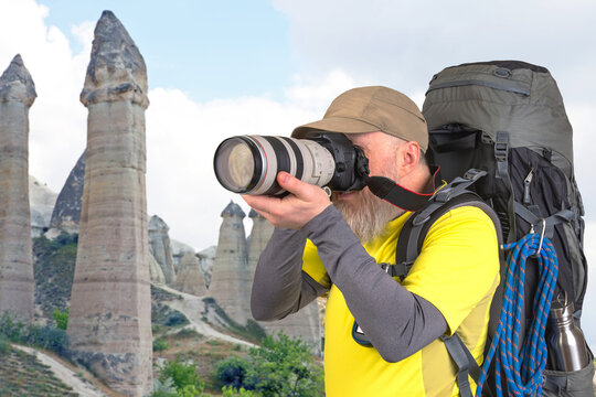 tourist photographer with a backpack photographs the beauty of nature in the mountains. nature hikes in the mountains