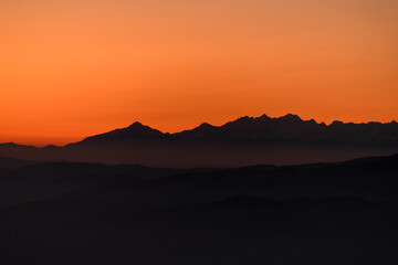Fantastic winter landscape during sunset: colorful sky glowing by orange sunlight.