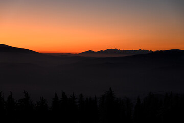 Fantastic winter mountains landscape during sunset: colorful sky glowing by orange sunlight.