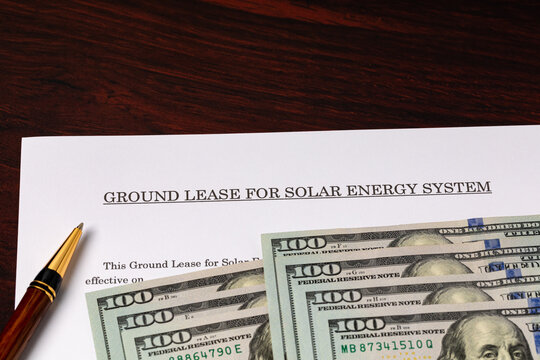 Solar energy ground lease with cash money. Solar farm contract, agriculture and renewable energy concept.