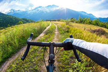 hands on the handlebars of a bicycle of a cyclist riding along a trail in nature. Point of view © photosaint