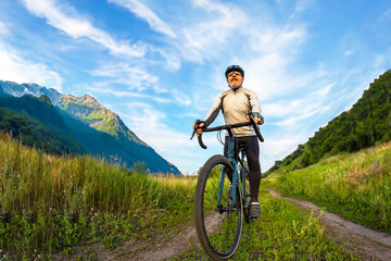 bearded man cyclist rides a bike on a road in nature. sports, hobbies and entertainment for health