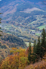 Fototapeta na wymiar Valley with houses in autumn colors of leaves.