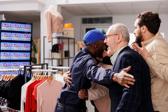 Black Friday Fight Between Security Guard And Crazy Crowd At Clothes Shop Entrance. Eager Shoppers Lined Up In Department Store, Waiting For Sales, Police Officer Holding Back People Customers