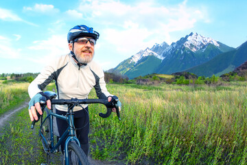Fototapeta premium bearded man cyclist rides a bike on a road in nature. sports, hobbies and entertainment for health