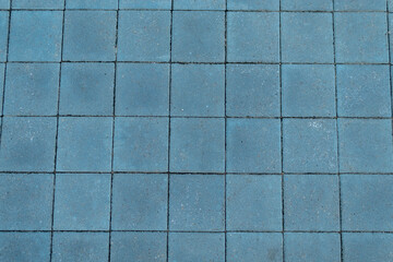The texture of the paved tile on the bottom of the street. Cement brick squared stone floor background.