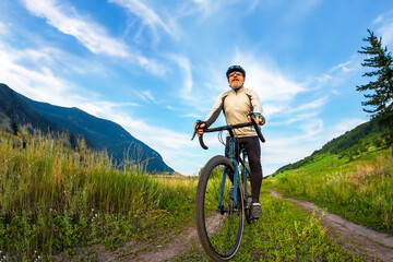 Naklejka premium bearded man cyclist rides a bike on a road in nature. sports, hobbies and entertainment for health
