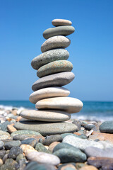 Fototapeta na wymiar Pyramid of stones on the seashore. balance and harmony of life and rest