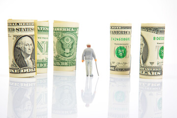 Miniature people. an elderly pensioner man stands near dollar money. concept of time and provision of old age