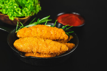 Breaded chicken nuggets. Semifinished chicken nuggets from chicken fillet on a dark background with fresh herbs. Quick cooking at home. Fast food. Breaded Chicken Inner Fillet.