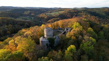 An aerial view of the beautiful ruins of Wlen Castle, in the town of Wlen, Lower Silesia in Poland, at the foot of the Karkonosze Mountains on the Bobr River, in autumn just before sunset. © Grzegorz
