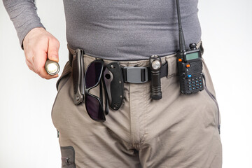 walkie-talkie, flashlight, knife on the belt of the tourist trekking pants. equipment for tourism...