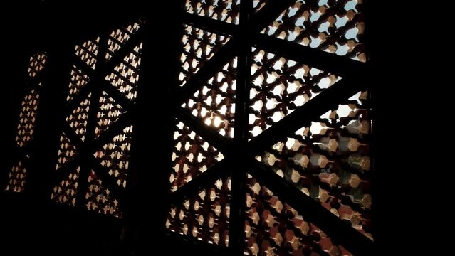 Sun shining through carved window shades close
