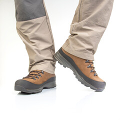 Trekking boots for hiking on the legs of a tourist on a white background. Equipment for travel and hiking