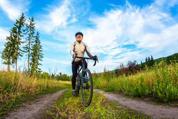 bearded man cyclist rides a bike on a road in nature. sports, hobbies and entertainment for health